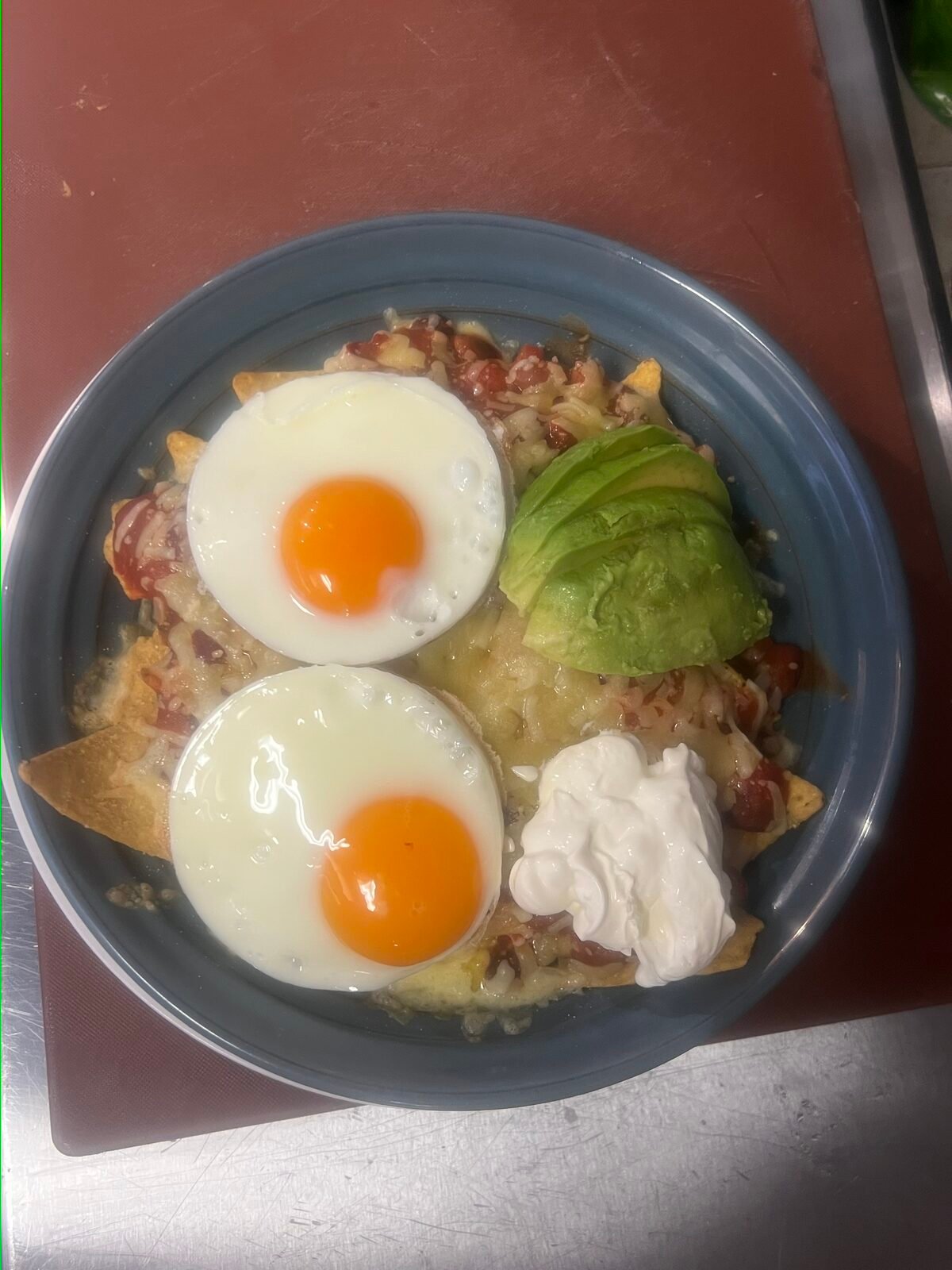 Loaded nachos with fried eggs and avocado
